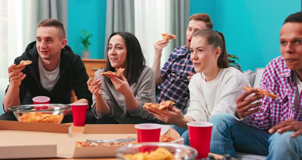 Joyous Multiethnic Friends are Eating Cheesy Pizza Chatting Relaxing During Indoor Party in alt
