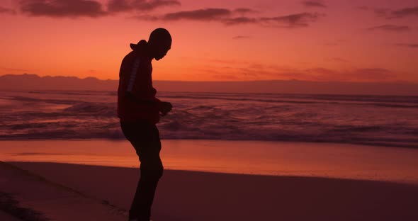 Young Sporty Black African Man Dancing in Evening Sun on the Beach