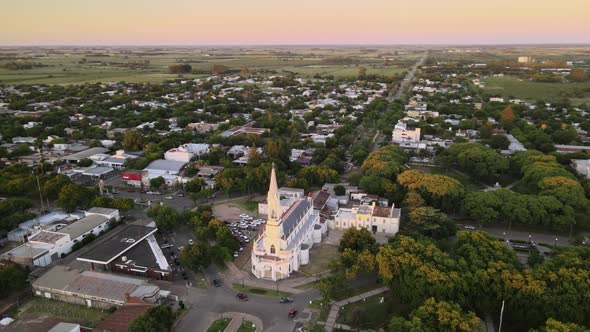 Aerial establishing shot of Virgen Niña church in Villa Elisa town, Argentina alt