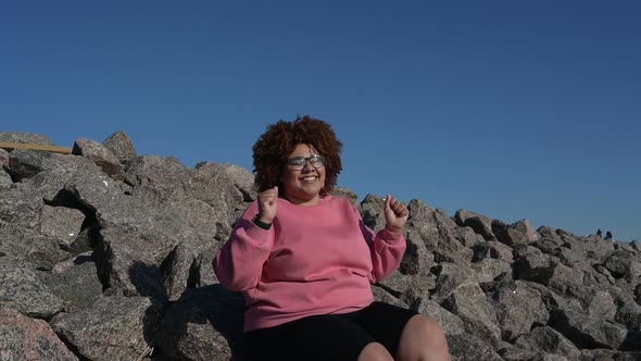 Beautiful Happy Smiling Plus Size African Black Woman Afro Hair in Pink Hoody Outdoor Laughing