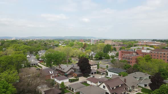 View over older well maintained residential neighborhood with light clouds and mountains in back.