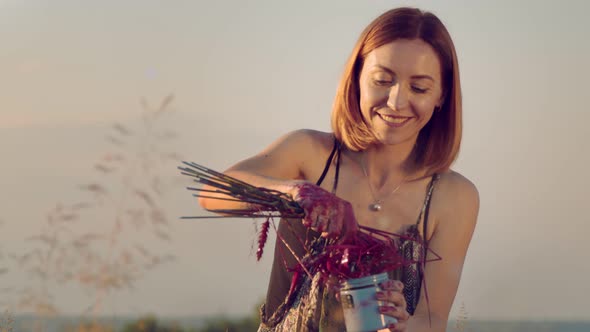 The Face of a Woman Who Is Smiling While Painting a Picture with an Improvised Handful of Wheat alt
