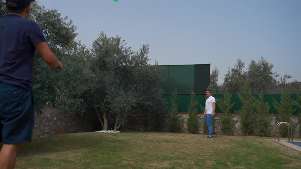 Man Tries to Catch Frisbee Launched By Friend on Yard Lawn alt