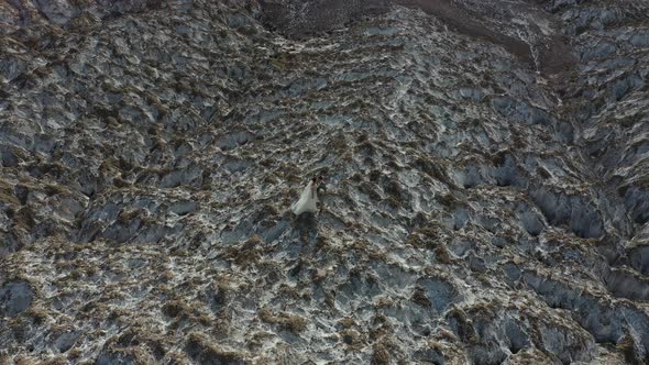 a Young Wedding Couple Stands on a Salt mountain.The Wind Blows the Veil, Against the Background  alt