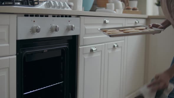 Woman Puts a Baking Sheet in the Oven