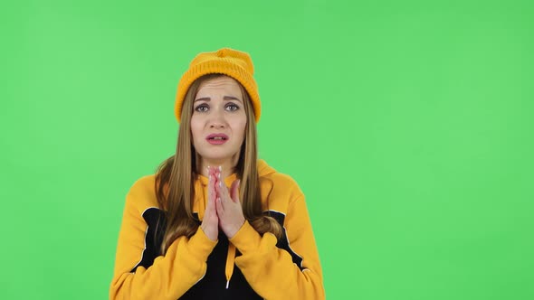 Portrait of Modern Girl in Yellow Hat Is Looking with Sympathetically, Folded Arms alt