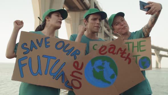 Activists with Posters Shooting Themselves on Smartphone Camera alt