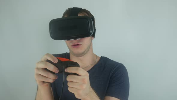 Man In A Virtual Reality Helmet Plays A Game Using A Gamepad