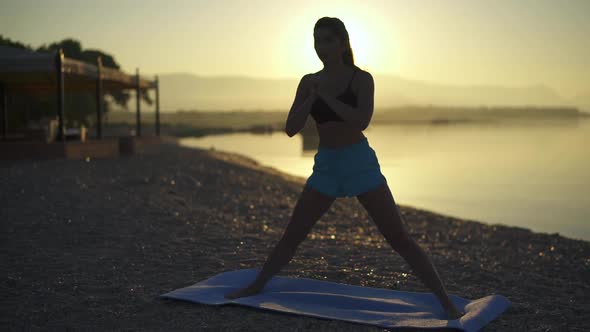 Beautiful Woman Trains on the Beach. Sea, Sunrise, Beach, Workout, Slow Motion