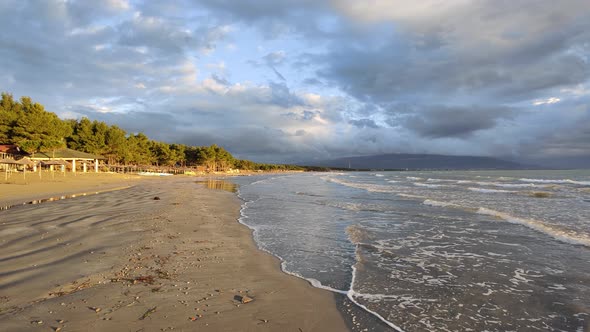 Beautiful sunset at a beach with the waves flowing alt