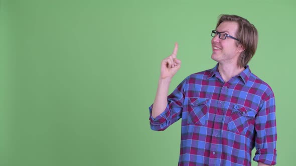 Happy Young Handsome Hipster Man Thinking While Pointing Up alt