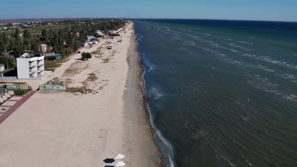 Beautiful flight in summer over the beach. People are resting near the sea. Houses for tourists. alt