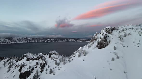 Aerial footage of ice covered caldera volcanic lake, Crater Lake, Oregon, USA alt