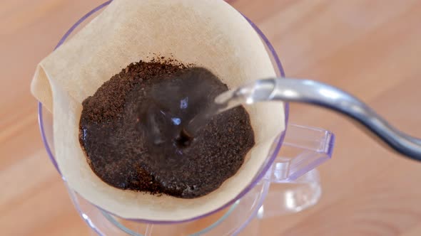 Water pouring to the coffee filter, making of hand drip coffee alt