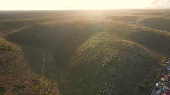 Aerial View of Drone Flying Towards Hills with Sun Glare