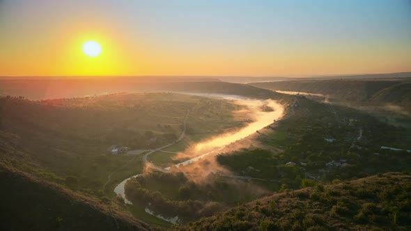 Aerial drone view of the Old Orhei at sunset. Valley with river and fog, village, monastery located  alt