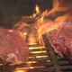 Two juicy pieces of raw meat are roasted on a hot grill over an open flame. BBQ. - VideoHive Item for Sale