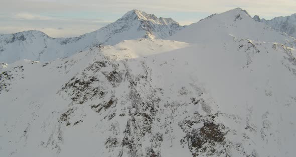 Aerial closeup helicopter shot, zooming out through tall buildings in downtown area of snowy city, d alt