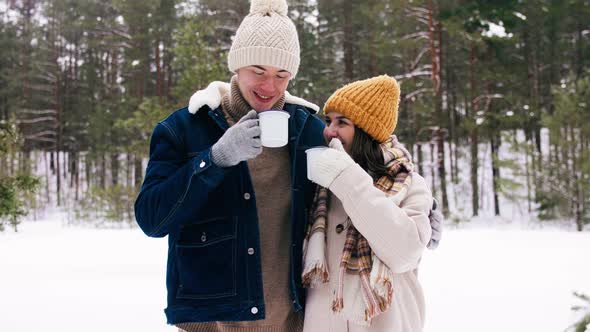 Happy Couple with Mugs Drinking Tea in Winter Park