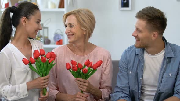 Aged Mother and Wife With Tulips Bouquets Sitting Near Male, Smiling on Camera alt