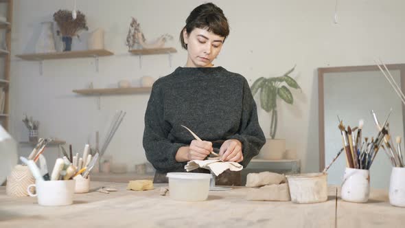 Young woman working with clay and ceramics in the workshop.