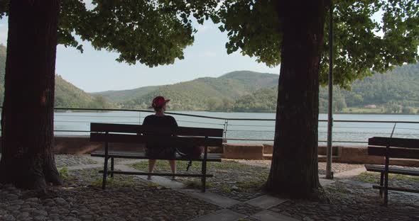 Woman sitting on the bench near the Bolsena lake