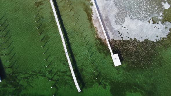 Top down view of snow covered docks in a partly frozen lake.