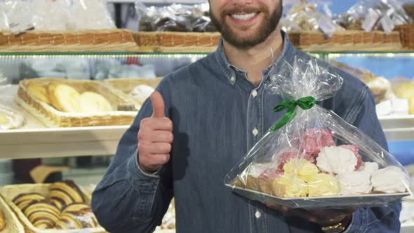 Cropped Shot of a Happy Bearded Man Showing Thumbs Up at the Bakery