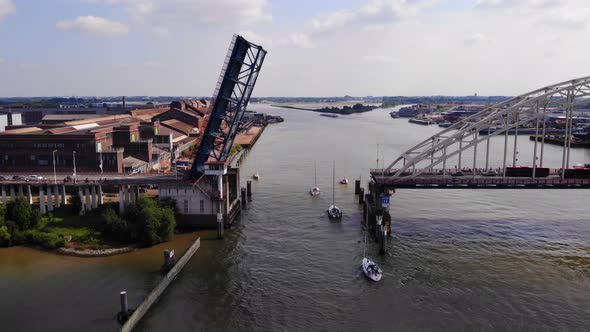 Sailboats Passing By Opened Bascule Bridge In Noord River, Alblasserdam, Netherlands. drone descend alt