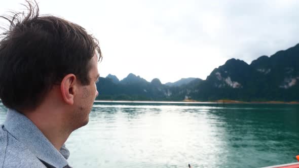 Slow Motion of Man in Boat on Morning Lake with Mountains and Pointing a Finger alt