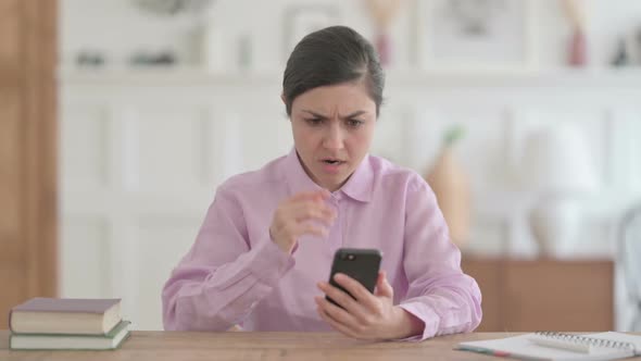 Upset Indian Woman Reacting to Loss on Smartphone alt