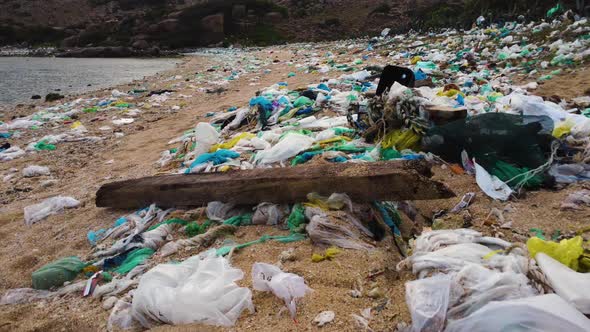 Plastic bags and marine debris littering sandy beach in Vietnam; drone alt