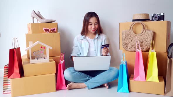 Happy young asian woman using credit card for online shopping concept