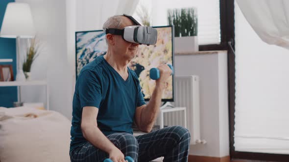 Handheld Shot of Elder Man Training with Dumbbells and Using Vr Glasses alt