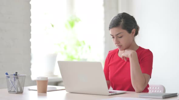 Indian Woman Thinking While Working on Laptop in Office alt