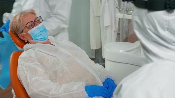 Patient with Dental Bib and Protection Mask Talking with Doctor alt
