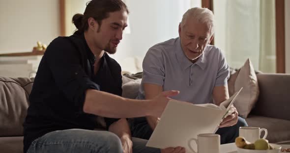 Father and Son Examining Photos Together alt
