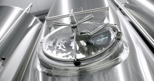 Stainless steel tanks for brewing beer Huge stainless vats in a brewery. alt