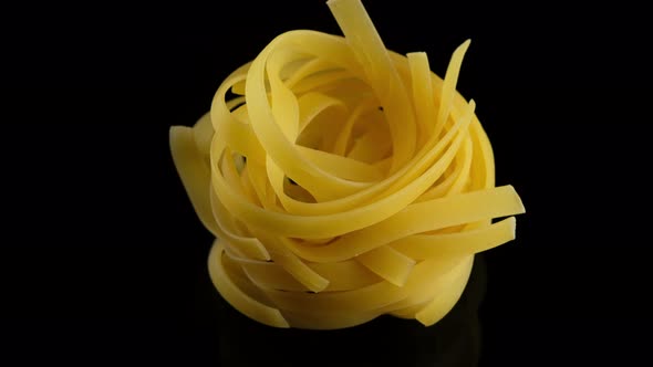 Traditional Italian Pasta tagliatelle on black background, rotation. 4K UHD video alt