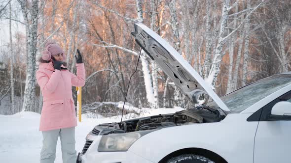 Woman Near Broken Car Calling for Help in Winter alt
