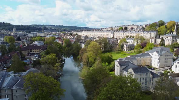 River Avon in Bath, UK. the sun shines on Walcot and the Paragon, the wider town in the background alt