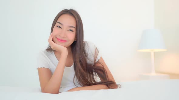 Asian woman relax on bed in bedroom interior