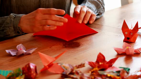 Woman preparing origami with paper at home 