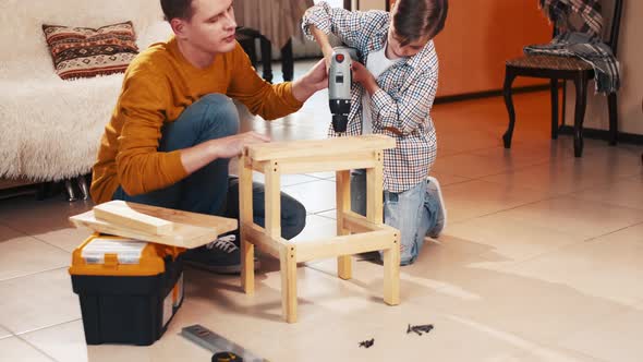 Father and son making stool together