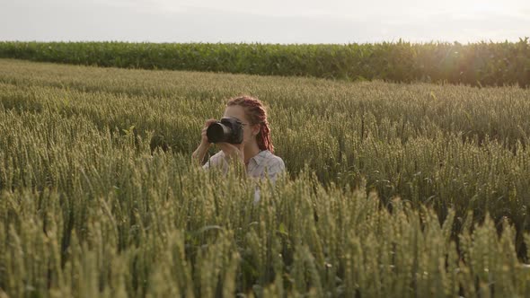 Redhaired Girl Takes Photos of a Agricalture Fileds alt