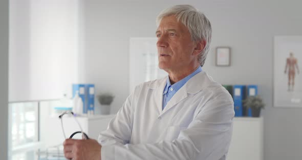 Portrait of Mature Male Doctor Standing in the Hospital Office