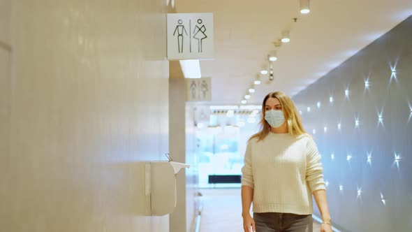Woman in a Protective Mask Comes Out of WC Liquid Alcohol Hand Sanitizer alt