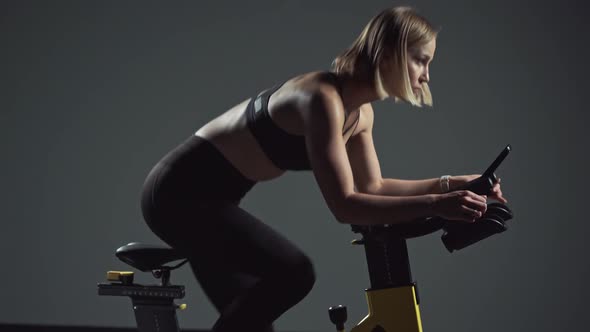 Cycle Training Young Woman is Engaged in Fitness on a Spin Bike Performs Aerobic Endurance Training alt