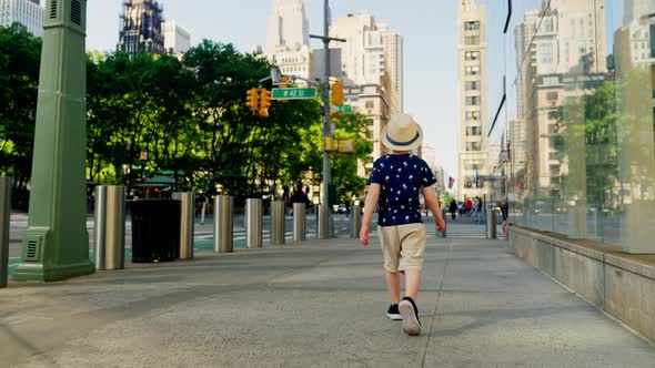 Boy In Hat Walking Through New York City Streets alt