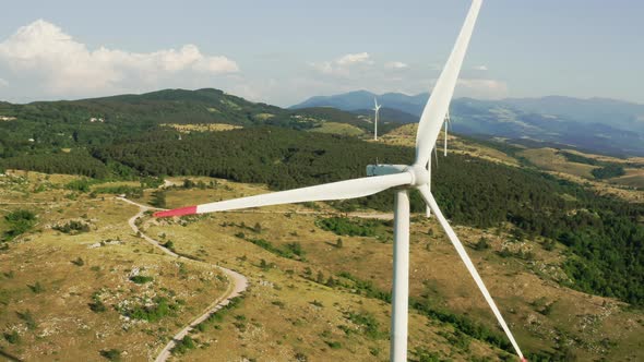 Camera Turns Around of a Spinning Wind Turbine in the Mountains alt